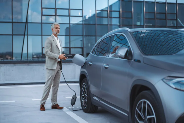 a man charging an electric car with level 1 charger